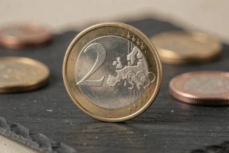 Pièce commémorative 2 euros Jeux Olympiques 2026 en gros plan sur ardoise sombre avec détails du relief
